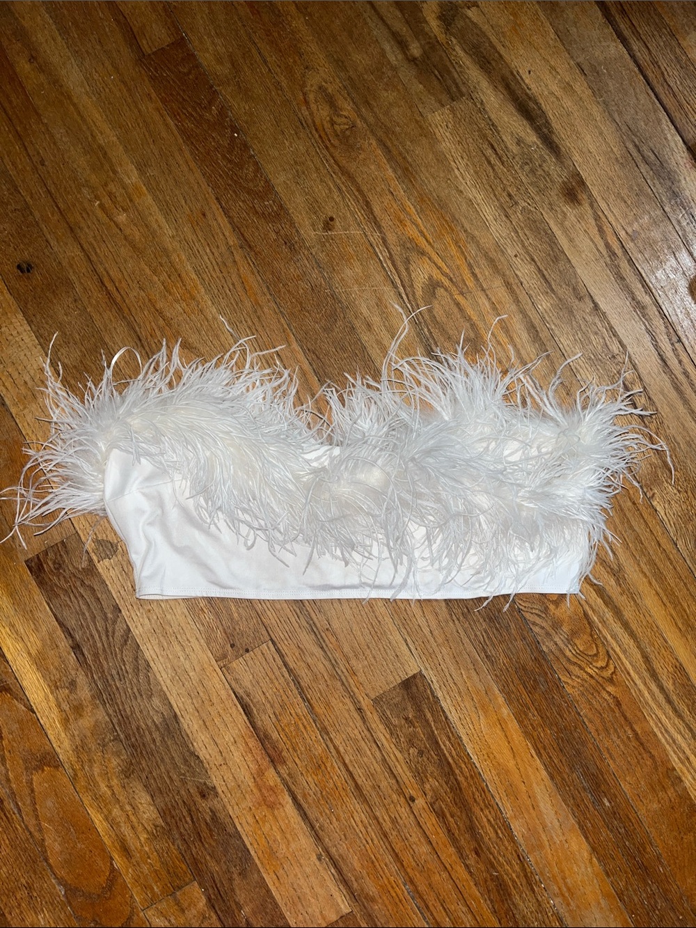 White satin tube top with feather trim.